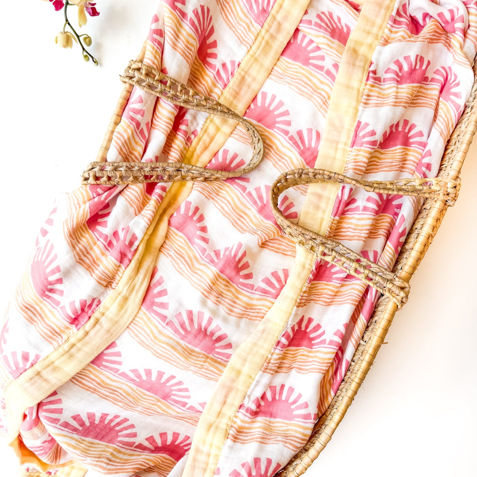 sun and wave print organic muslin baby blanket with yellow trim. Double sided and extra soft, printed in delicate pink sun andwave.