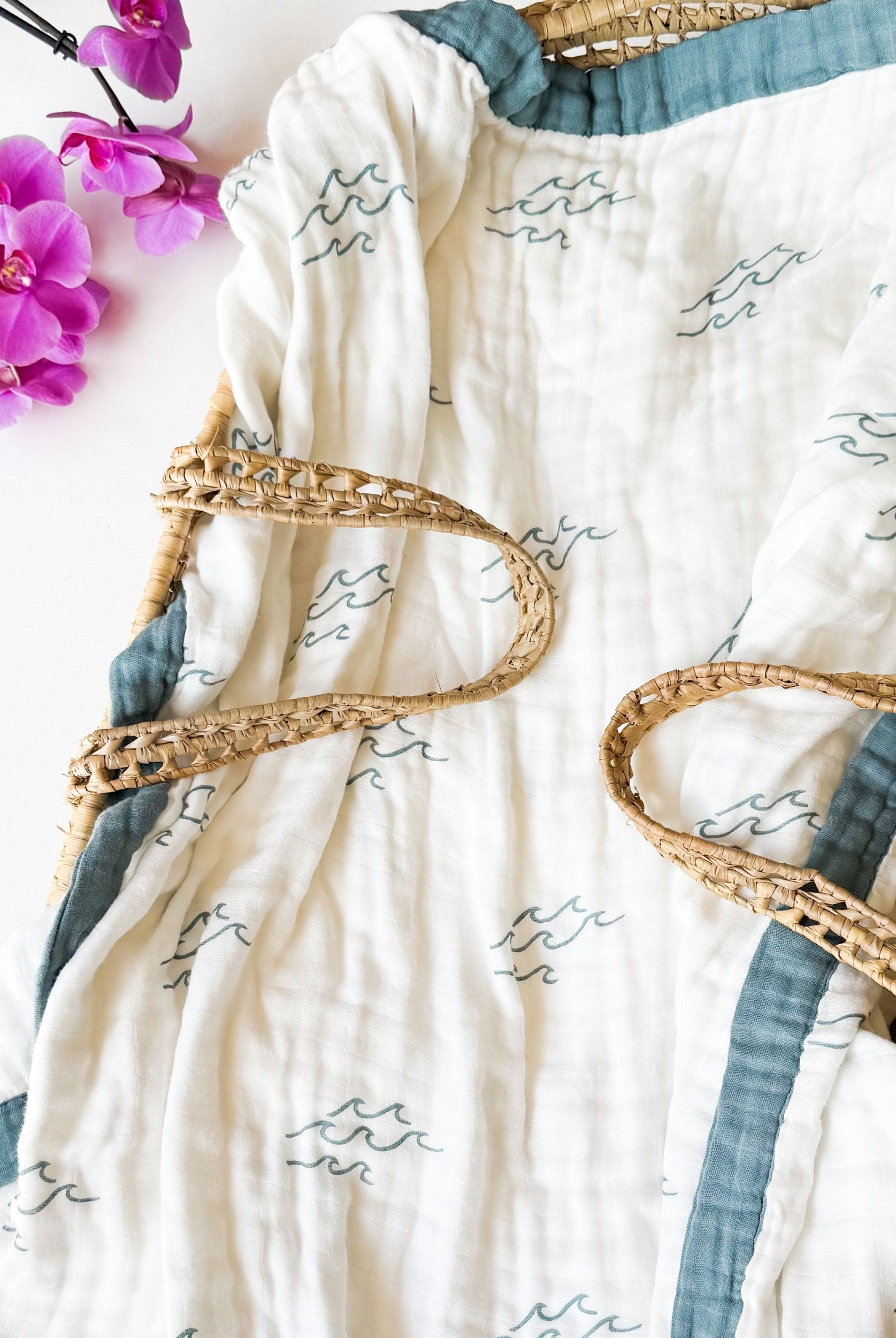 surfer wave print organic muslin baby blanket with blue trim. Double sided and extra soft, printed in delicate minimalist wave.