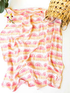 coastal cowgirl nursery decor. Pink sunset wave and sun swaddle