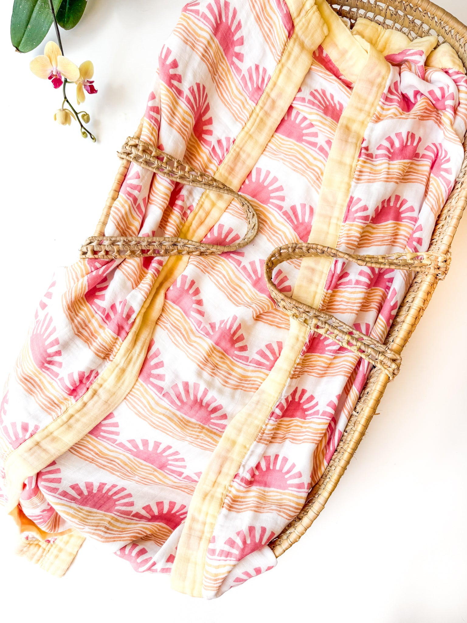 sun and wave print organic muslin baby blanket with yellow trim. Double sided and extra soft, printed in delicate pink sun andwave. 