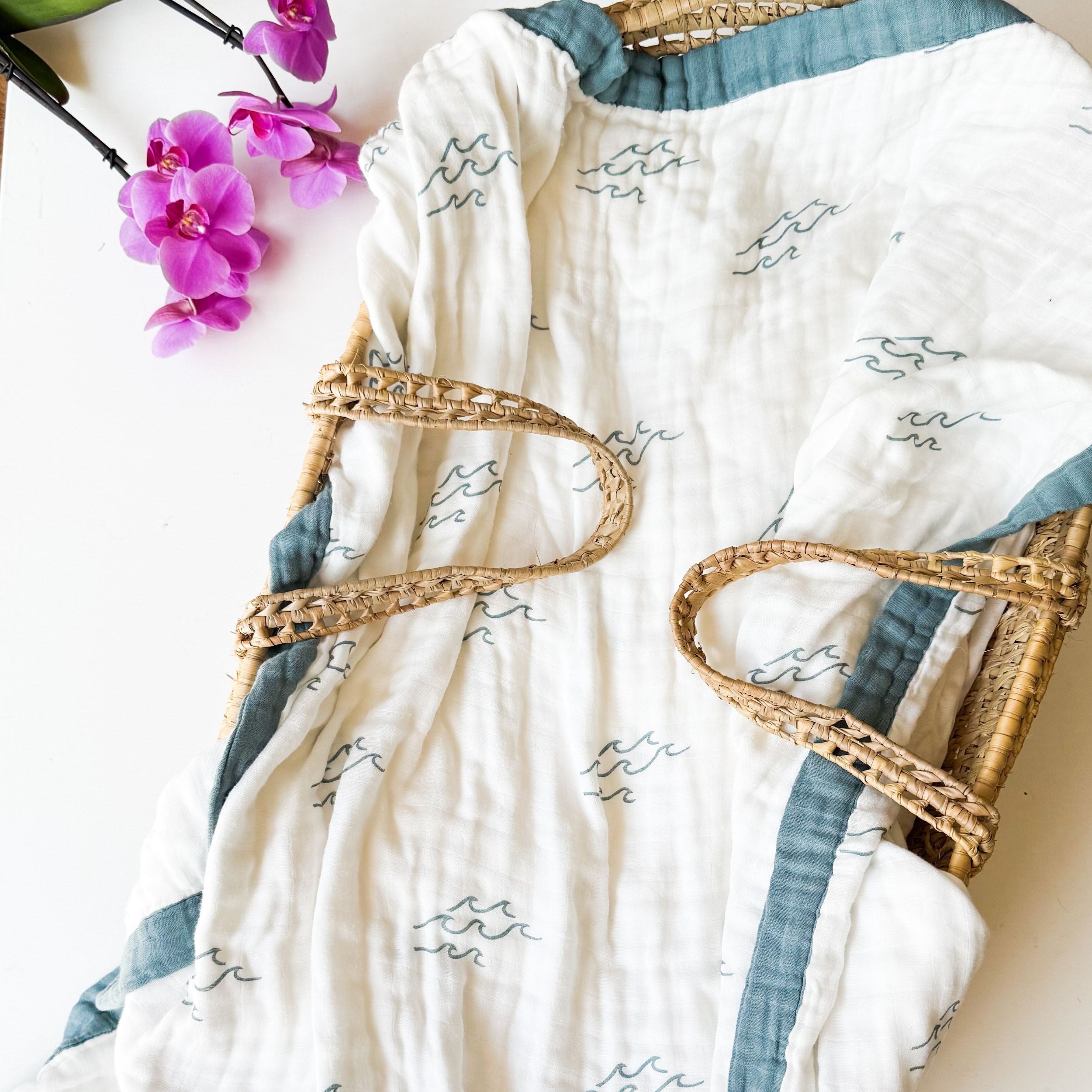 surfer wave print organic muslin baby blanket with blue trim. Double sided and extra soft, printed in delicate minimalist wave. 