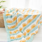 ocean wave and sun print bamboo muslin baby blanket with baby in basket